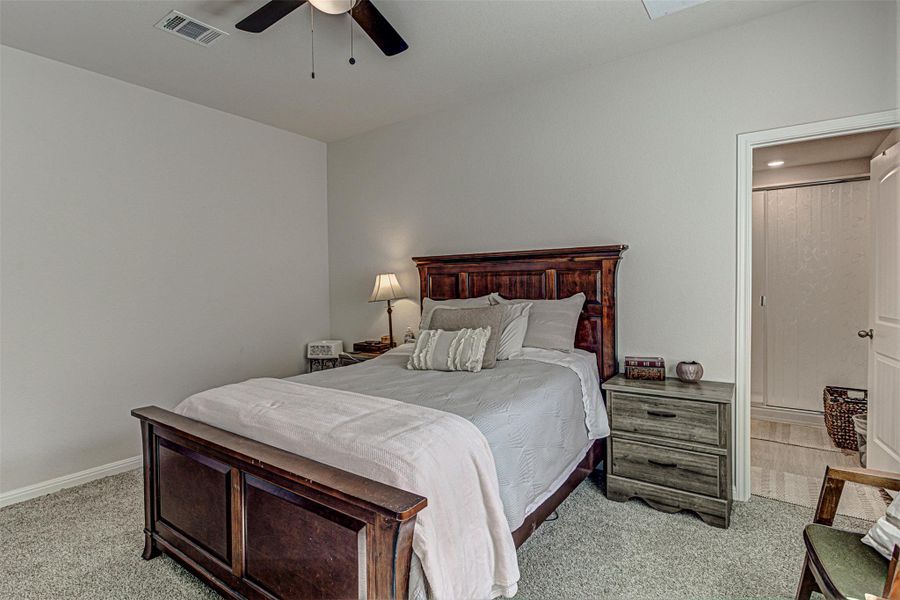 Bedroom with light carpet and a ceiling fan