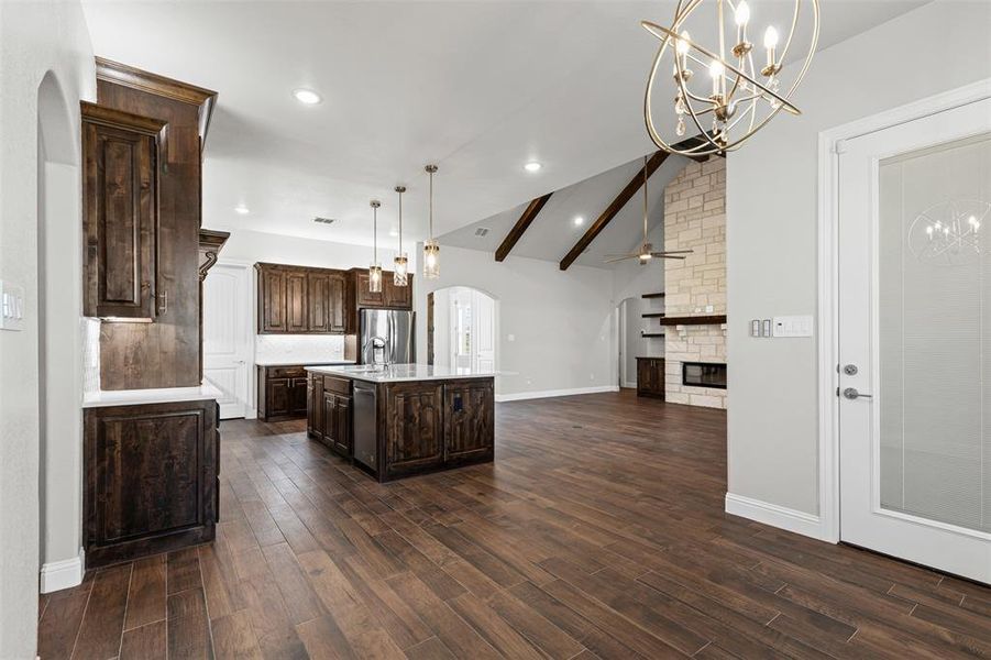 Kitchen featuring arched walkways, a chandelier, dark brown cabinetry, pendant lighting, and recessed lighting Kitchen featuring arched walkways, a chandelier, dark brown cabinetry, pendant lighting, and recessed lighting