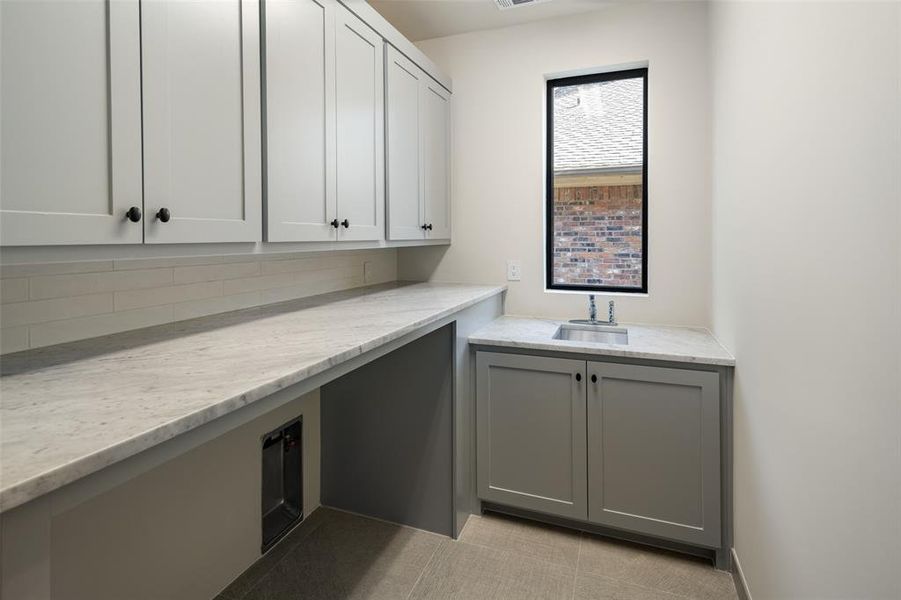 Laundry room with light tile patterned floors and sink