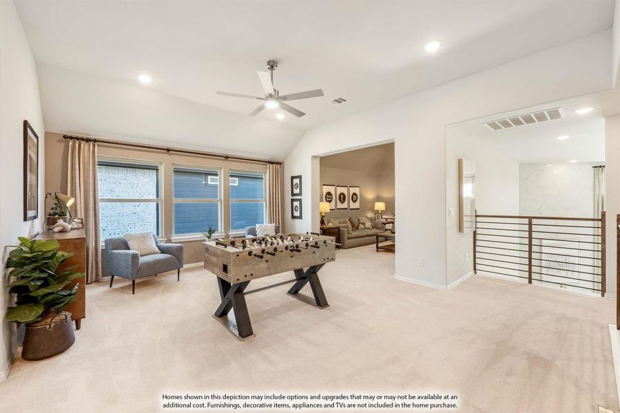 Upstairs game room with foosball table, carpet, ceiling fan, and open railing overlooking lower level Upstairs game room with foosball table, carpet, ceiling fan, and open railing overlooking lower level