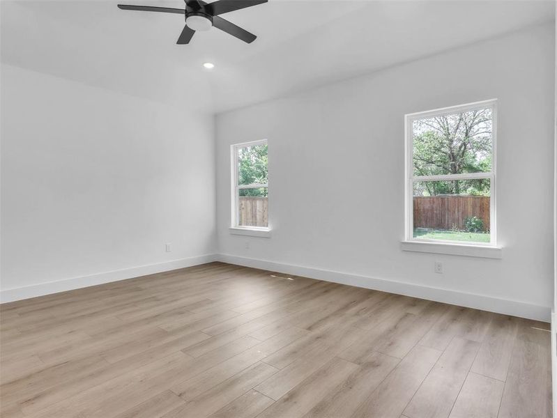 Spare room with light wood-type flooring, a ceiling fan, and baseboards Spare room with light wood-type flooring, a ceiling fan, and baseboards