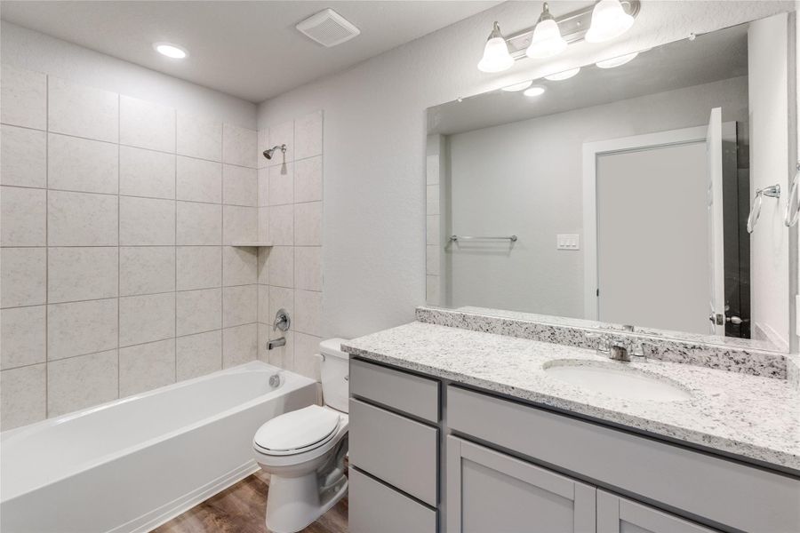 Bathroom with shower / bathtub combination, vanity, dark wood finished floors, and recessed lighting Bathroom with shower / bathtub combination, vanity, dark wood finished floors, and recessed lighting