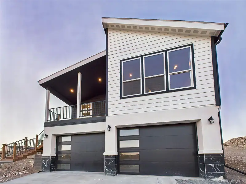 Contemporary elevation with striking black-and-white contrast, garage, and architectural windows. Contemporary elevation with striking black-and-white contrast, garage, and architectural windows.