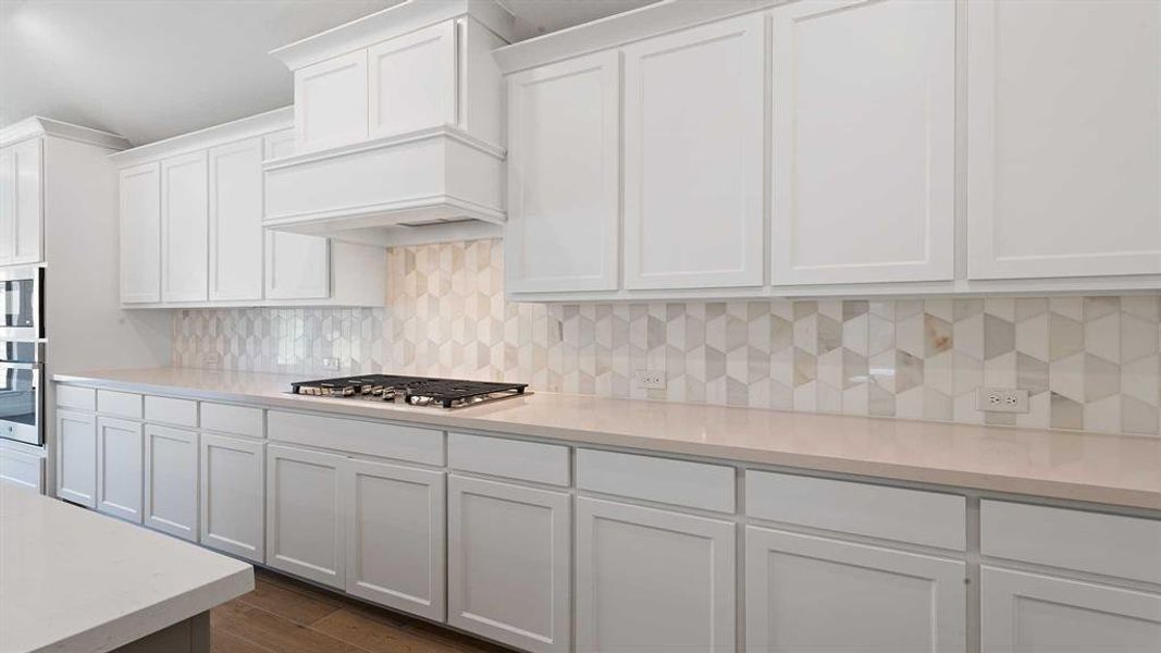 Kitchen featuring white cabinetry, decorative backsplash, dark hardwood / wood-style flooring, and stainless steel gas stovetop