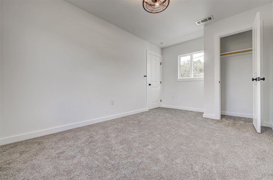 Unfurnished bedroom with light colored carpet and a closet