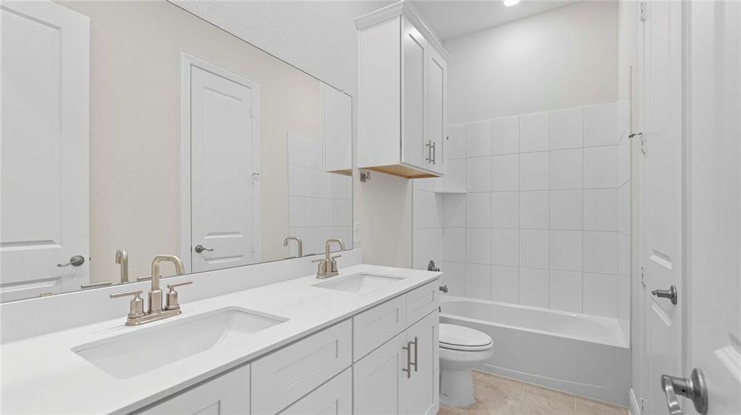 Bathroom featuring a double vanity with white cabinetry, light-colored countertops, and brushed nickel fixtures