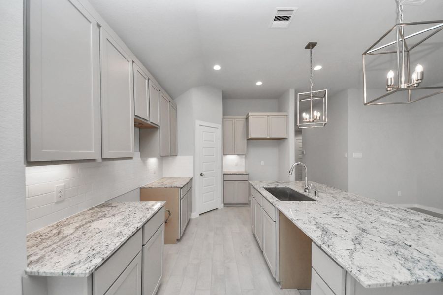 Discover another perspective of this stunning kitchen, generously appointed with an abundance of counter space.