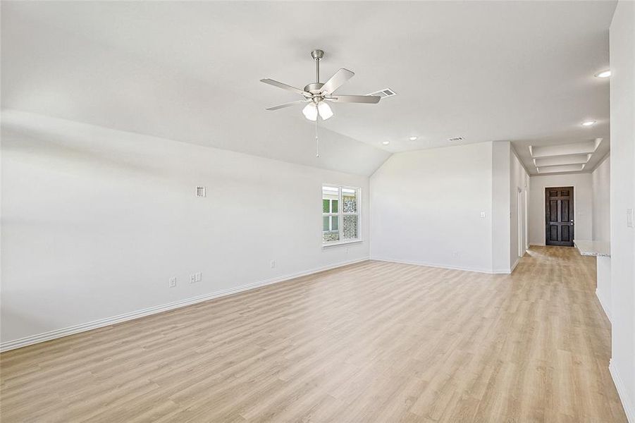 Unfurnished room with ceiling fan, light hardwood / wood-style floors, and vaulted ceiling