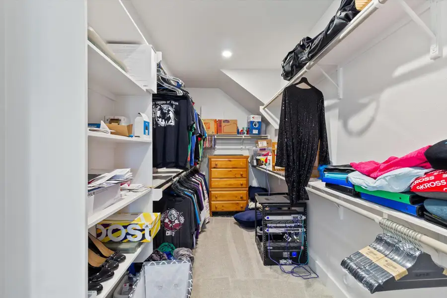Walk in closet featuring light colored carpet