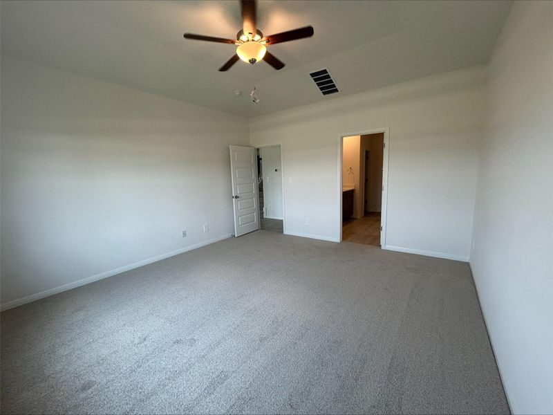 Unfurnished bedroom with carpet flooring, ensuite bath, and ceiling fan
