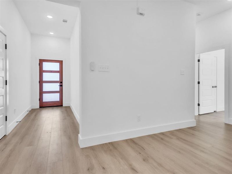 Entryway with recessed lighting, baseboards, visible vents, and light wood-style flooring Entryway with recessed lighting, baseboards, visible vents, and light wood-style flooring