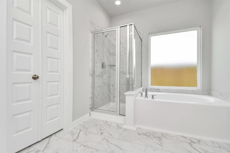 Enjoy a walk-in shower with tile surround, a separate garden tub with custom detailing. Sample photo of completed home with similar floor plan. As-built interior colors and selections may vary.