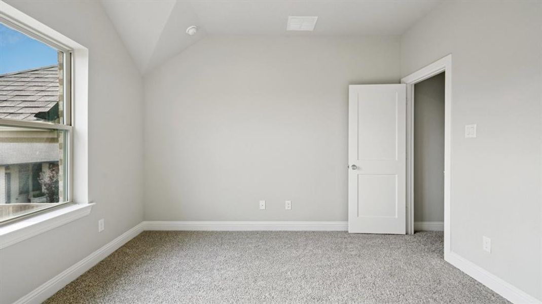 Unfurnished room featuring carpet and vaulted ceiling Unfurnished room featuring carpet and vaulted ceiling