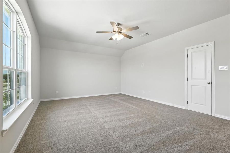 Carpeted empty room featuring ceiling fan and baseboards Carpeted empty room featuring ceiling fan and baseboards