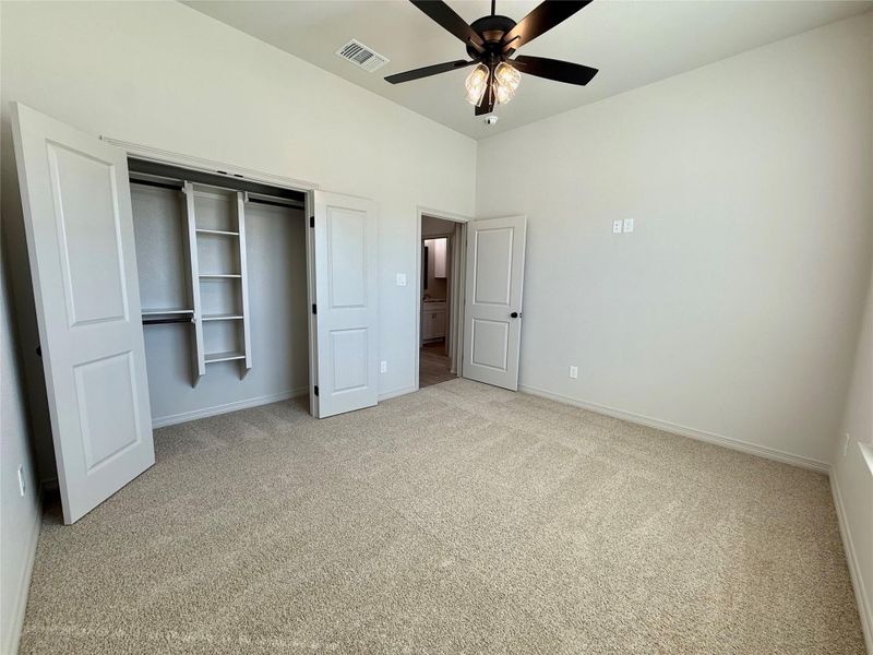 Unfurnished bedroom featuring carpet flooring, a closet, and ceiling fan