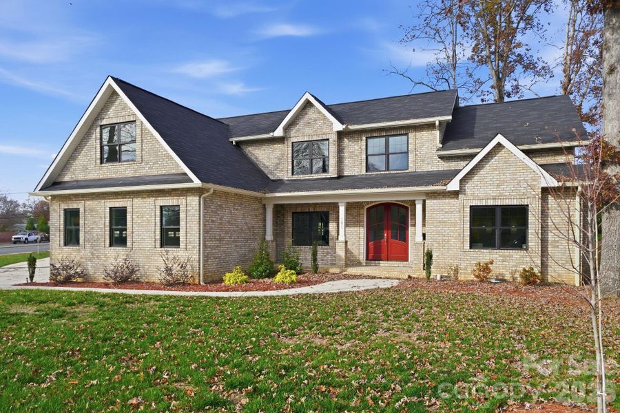 Angled front view showcasing architectural details and expansive front yard. Angled front view showcasing architectural details and expansive front yard.