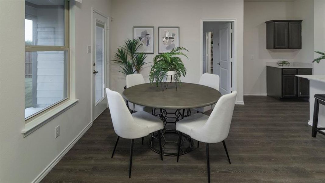 Dining area featuring wood-finish flooring, a contemporary door with a window pane, and a large window Dining area featuring wood-finish flooring, a contemporary door with a window pane, and a large window