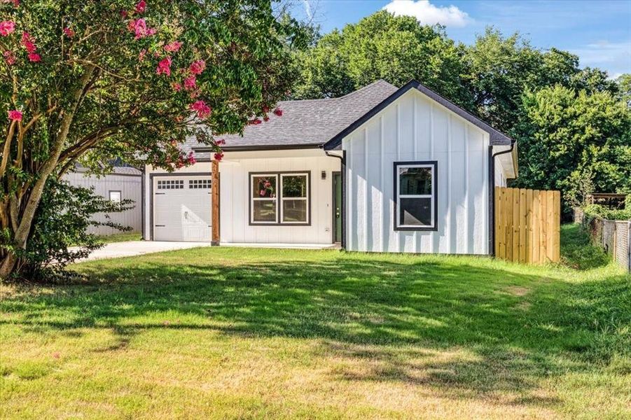 View of front of property with a garage and a front yard