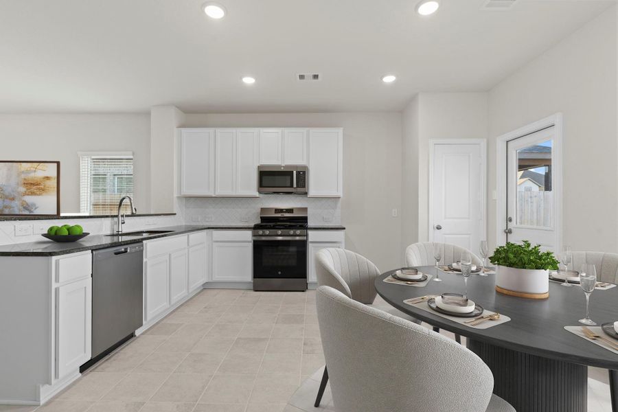 A wider look at the kitchen reveals abundant cabinet storage and a clean, modern design. The open layout flows naturally into the dining area, making gatherings effortless and inviting.