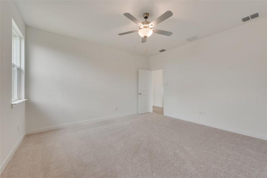 Spare room with light carpet and ceiling fan