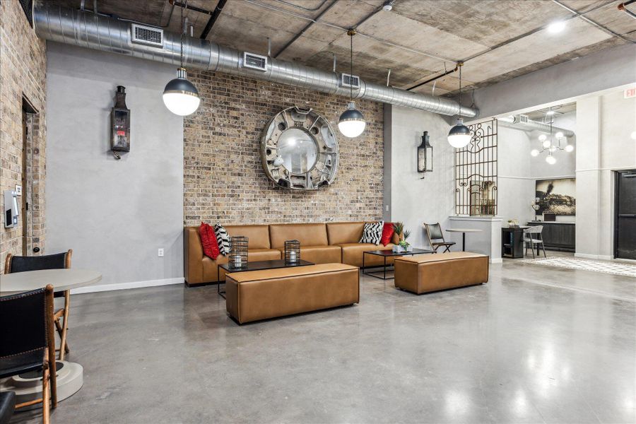 Exposed brick walls and concrete flooring define this open-concept common area, ideal for relaxed gatherings. Exposed brick walls and concrete flooring define this open-concept common area, ideal for relaxed gatherings.