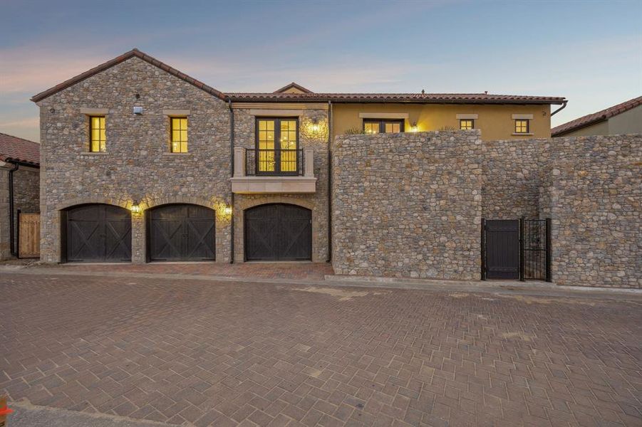 Mediterranean / spanish home featuring a balcony, decorative driveway, and an attached garage