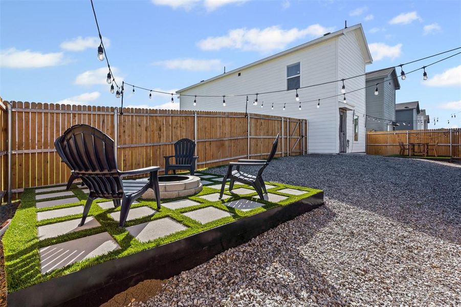 Fenced backyard with an outdoor fire pit and a patio area