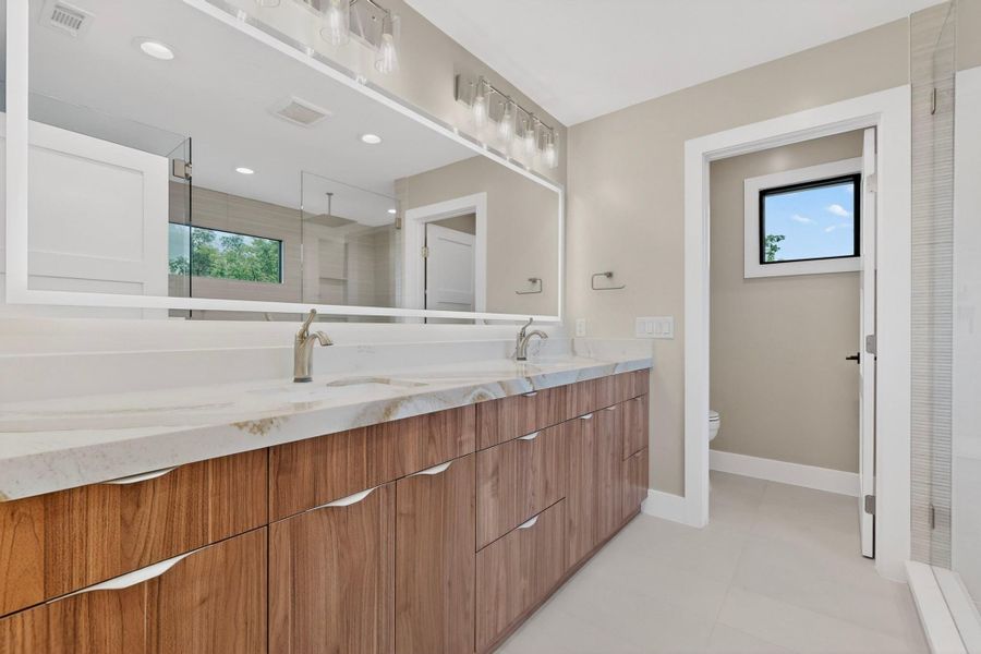 A well-appointed bathroom offers a double vanity with ample counter space and a sleek, modern design.