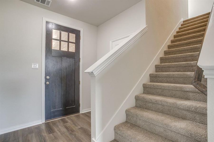 Foyer entrance with wood finished floors and stairway