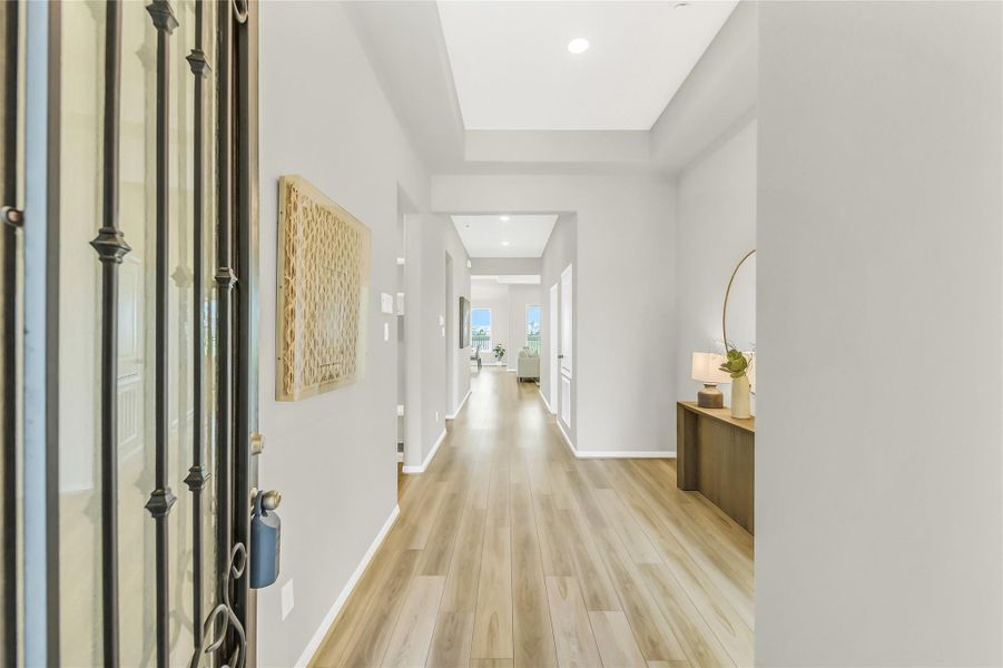 Grand foyer featuring 11-foot tray ceilings and upgraded luxury vinyl plank flooring that extends throughout the home.