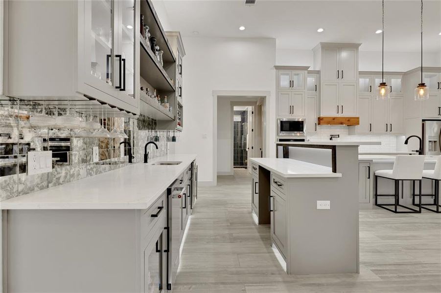 Custom cabinets and hardware for bar entertainment area as well as the kitchen. Tons of cabinets for storage and quartz counter tops for serving and prep.