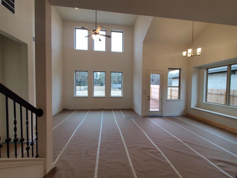 Interior space with a towering ceiling and ceiling fan with notable chandelier