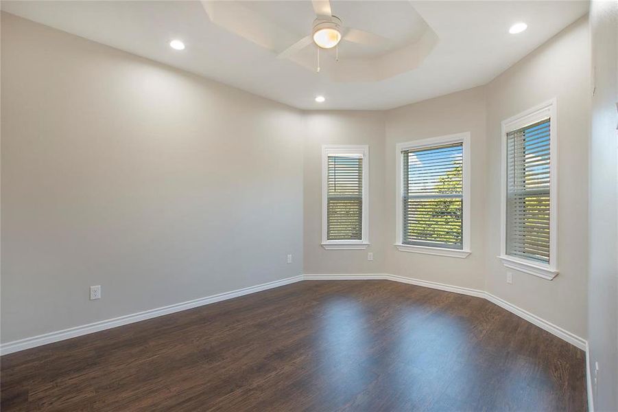 Unfurnished room featuring a raised ceiling, dark wood-type flooring, recessed lighting, and ceiling fan Unfurnished room featuring a raised ceiling, dark wood-type flooring, recessed lighting, and ceiling fan