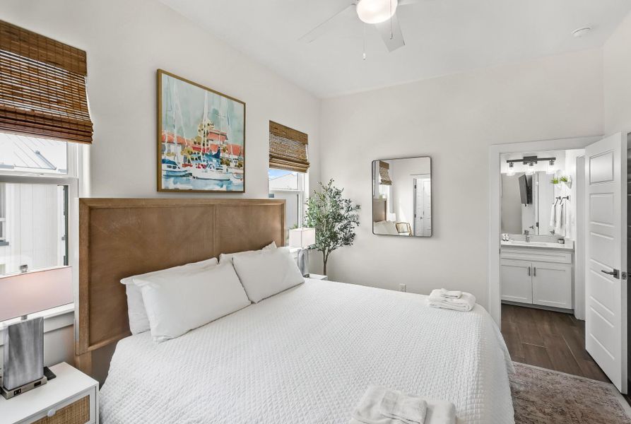 Bedroom with dark wood-type flooring, ceiling fan, and ensuite bathroom Bedroom with dark wood-type flooring, ceiling fan, and ensuite bathroom