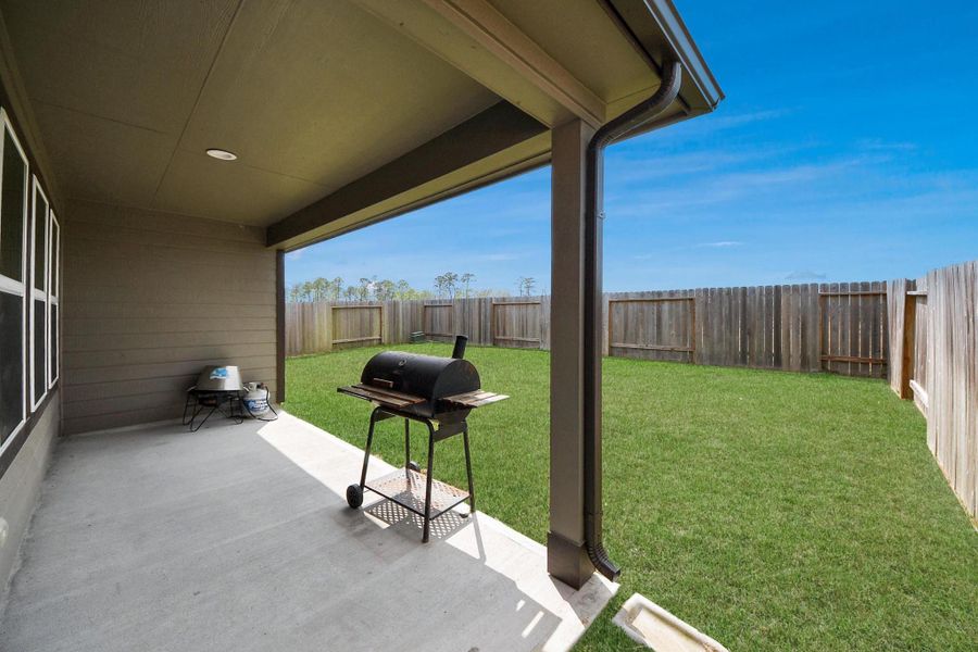 Step outside to a covered patio that overlooks the spacious, fully fenced backyard—perfect for outdoor dining, weekend BBQs, or simply enjoying the open green space with plenty of room to play or entertain.
