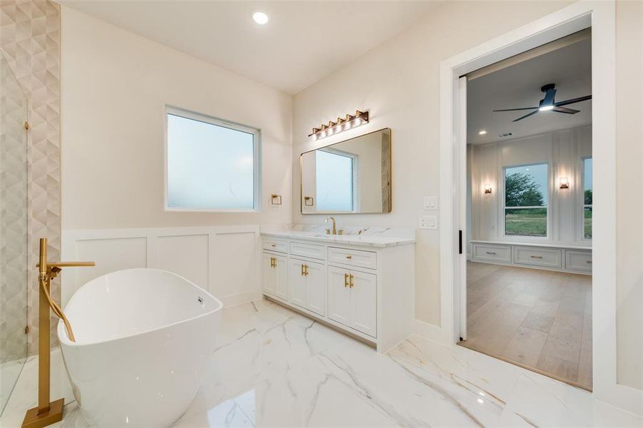 Bathroom with vanity, a freestanding tub, marble finish floors, recessed lighting, and a decorative wall Bathroom with vanity, a freestanding tub, marble finish floors, recessed lighting, and a decorative wall