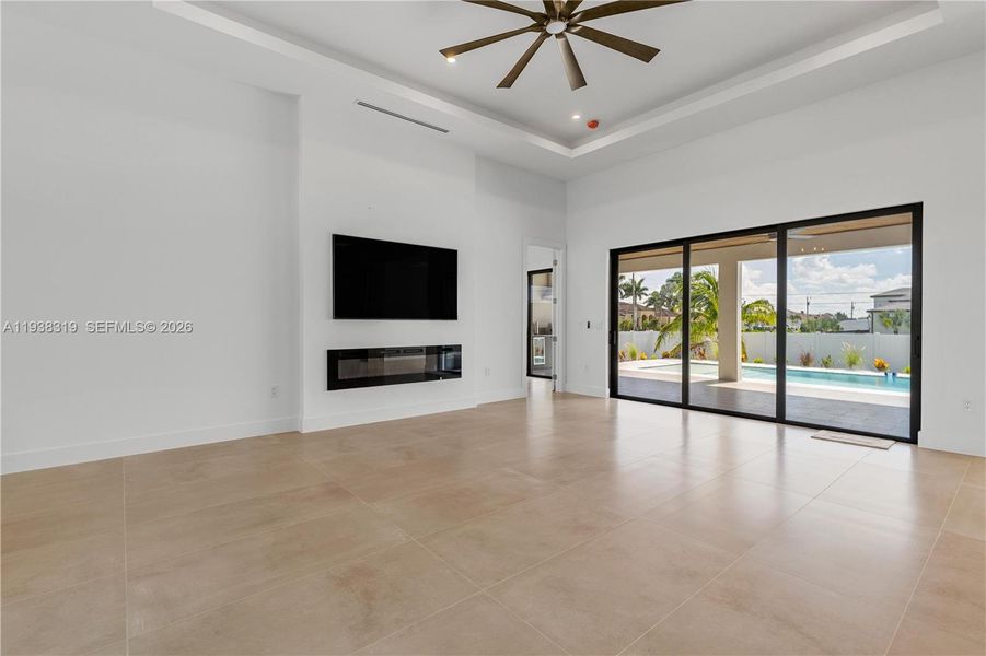 The EXPANSIVE LIVING AREA is a showstopper, featuring soaring 16-foot COVE CEILINGS, a dramatic FEATURE WALL with WALLPAPER, a 75-inch TV, and an ELECTRIC FIREPLACE that sets the PERFECT AMBIANCE.