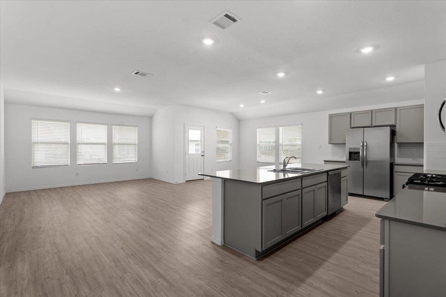 An open concept living area transitions seamlessly into a well-appointed kitchen with an inviting island. An open concept living area transitions seamlessly into a well-appointed kitchen with an inviting island.