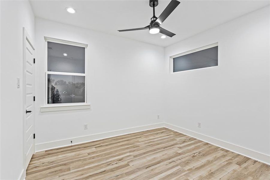 Empty room with ceiling fan and light wood-type flooring