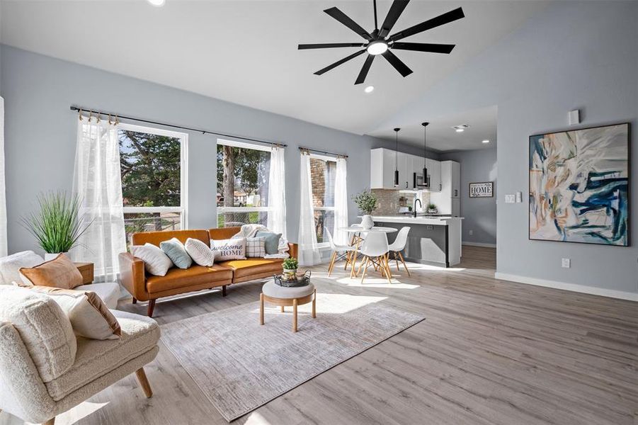 Living room featuring vaulted ceiling, light wood finished floors, recessed lighting, and ceiling fan Living room featuring vaulted ceiling, light wood finished floors, recessed lighting, and ceiling fan