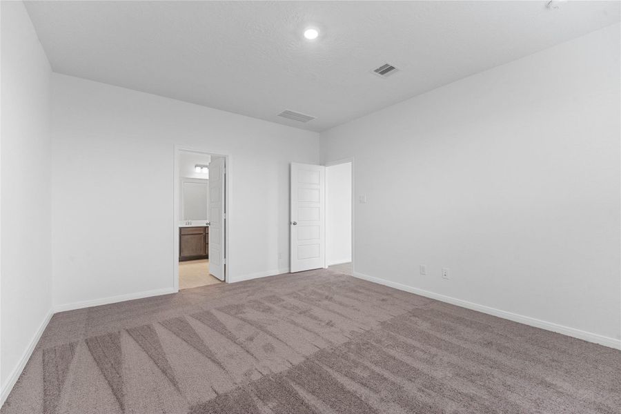 Additional view of the primary bedroom looking towards the primary bathroom.