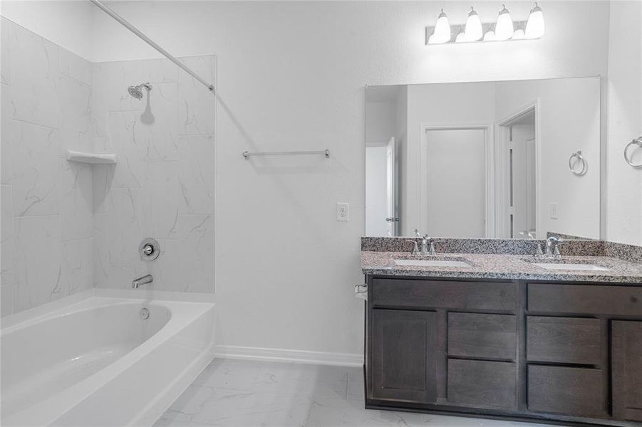 This primary bathroom is definitely move-in ready! Featuring a tub/shower combo with tile surround, stained cabinets with granite countertops, spacious walk-in closet with shelving, high ceilings, custom paint, sleek and modern finishes.