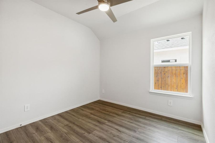 Empty room with vaulted ceiling, ceiling fan, and hardwood / wood-style floors