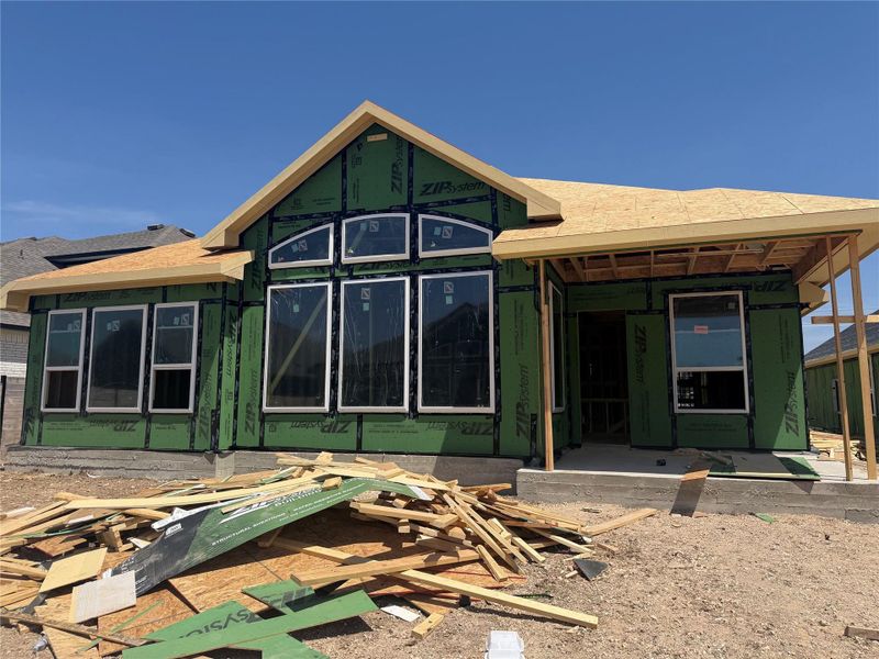 Progress continues on this new home construction featuring custom window openings and a covered entry.