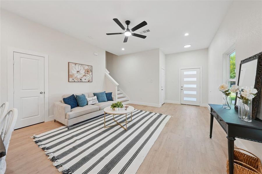 Living area featuring stairs, light wood-type flooring, recessed lighting, and ceiling fan Living area featuring stairs, light wood-type flooring, recessed lighting, and ceiling fan