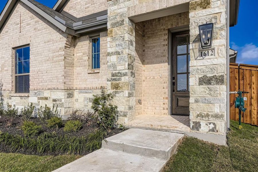 View of exterior entry with stone siding and brick siding View of exterior entry with stone siding and brick siding