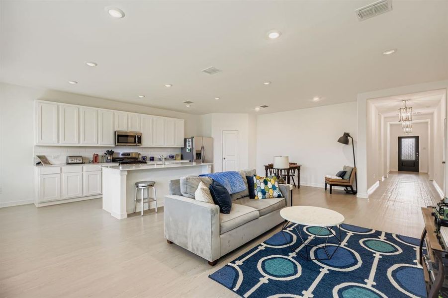 Living room with light wood-style floors and recessed lighting
