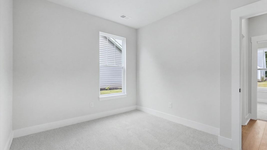 Accomplished design in this restful bedroom featuring plush carpet and an oversized window view in Anderson, SC