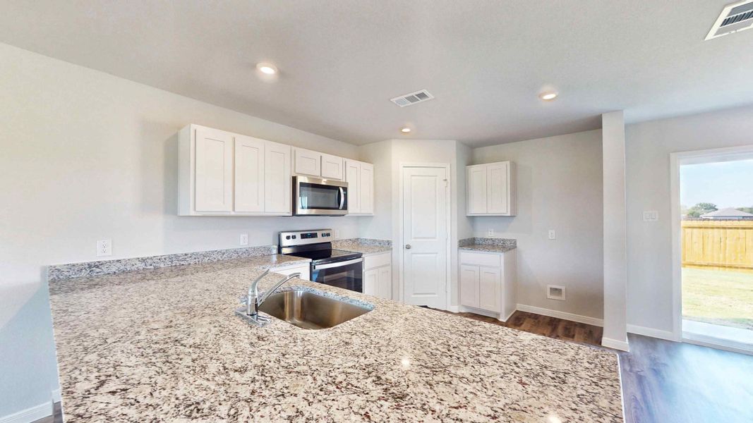 A kitchen with marble counters.