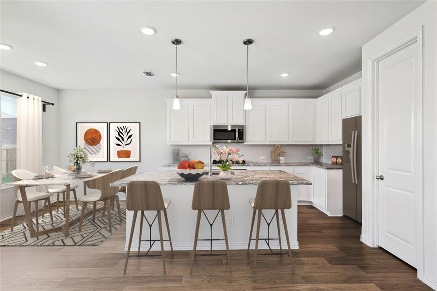 Kitchen featuring pendant lighting, light stone counters, dark hardwood / wood-style floors, white cabinetry, and stainless steel appliances